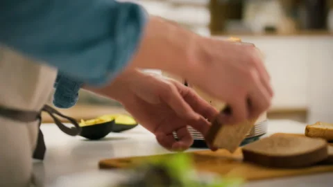 Toasting bread in a cozy kitchen setting with a vintage style toaster Stock Footage 331288027