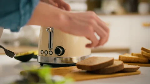 Toasting bread in a cozy kitchen with a vintage-style toaster for breakfast Stock Footage 305337397
