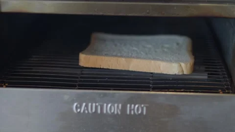 Toasting bread in a kitchen toaster for breakfast meal Stock Footage 332451424