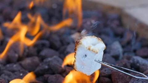 Toasting marshmallow on open flame of campfire slow mo Stock-Footage 106625296