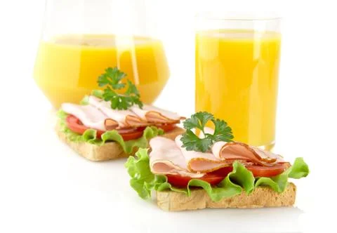 Toasts with cold cuts for breakfast with orange juice on white background Stock Photos