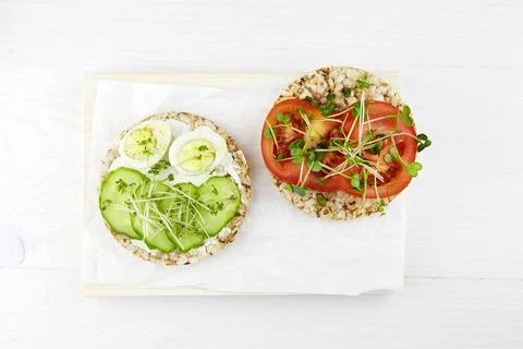 Toasts with egg, micro greens, cucumbers and tomatoes. Stock Photos