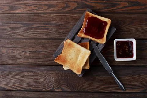 Toasts with jam on dark wooden table Stock Photos
