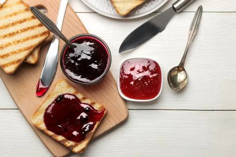 Toasts with jam. fried crispy toasts with red jam on a white wooden table. br Stock Photos