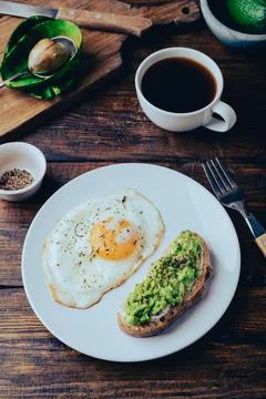 Toasts with mashed avocado and fried egg for breakfast Stock Photos