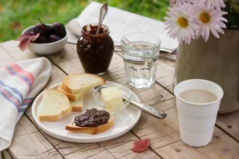 Toasts with plum chocolate jam and cocoa. Breakfast in the garden. Rustic sty Stock Photos