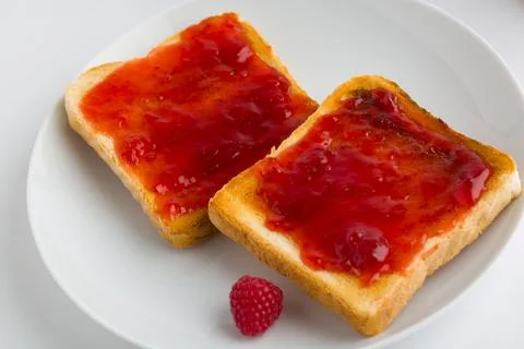 Toasts with raspberry jam on white plate Stock Photos