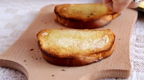 Toasts spreadet with butter on the board Stock Footage 66519441