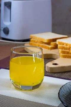 Toasts of white bread, toaster and glass of orange juice for breakfast, vertical 스톡 사진