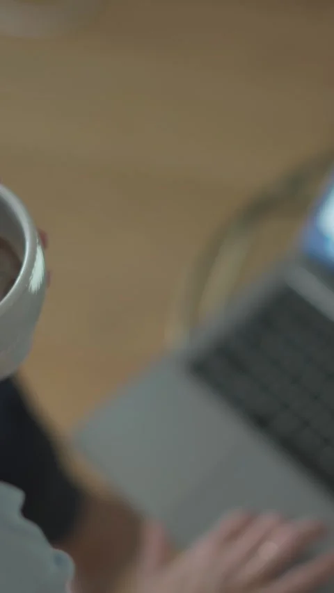 In todays evolving remote work landscape, a woman enjoys her coffee while Stock Footage 293207329