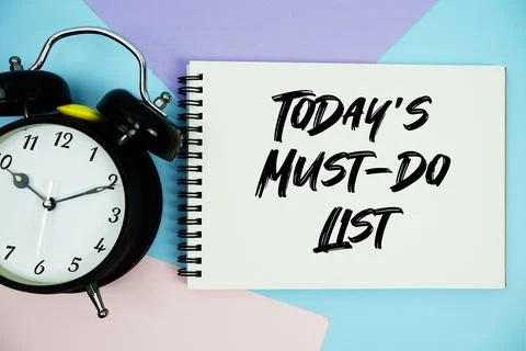 Todays Must-Do List text written on notepad with alarm clock flat lay on mu.. Stock Photos