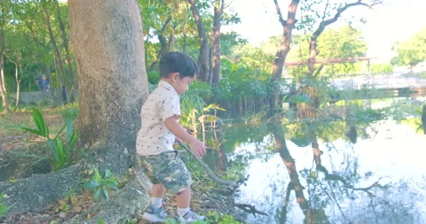 Toddler 2 year boy playing water in city park nature Stock Footage 143988956