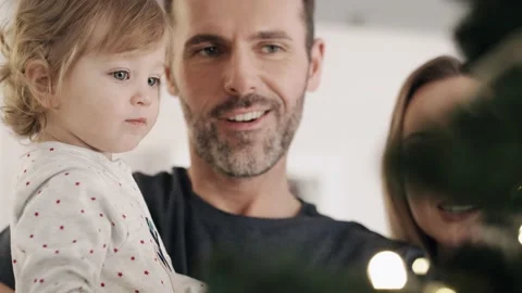 Toddler and her parents next to a Christmas tree. Stock-Footage 142364053