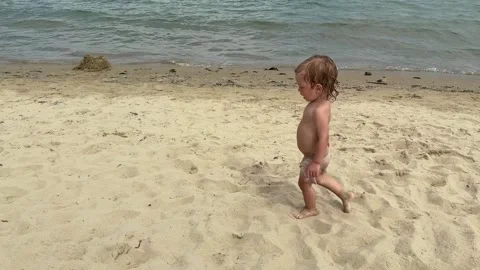 Toddler beach discovery with ball Stock Footage 336288956