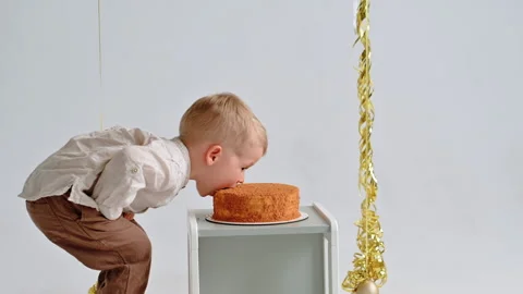 Toddler Biting Slice of Cake in White Studio Background Stock Footage 307308495