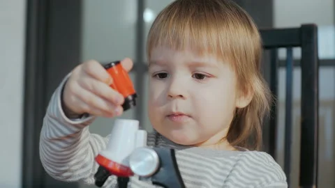 Toddler boy of 2-3 years old playing with a toy microscope. A child repairing a Video stock 151736485