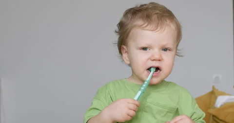 Toddler boy brushing teeth alone in bedroom in apartment 動画素材 253627616
