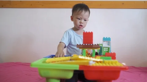 Toddler boy child having fun playing with colorful building blocks Stockbeeldmateriaal 99276778