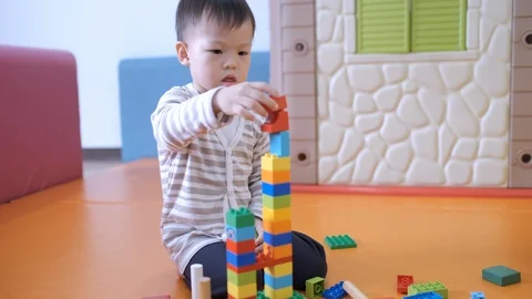 Toddler boy having fun playing with colorful plastic blocks  Stockbeeldmateriaal 101462246