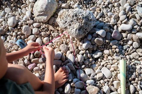 Toddler boy knitting a string bracelet Stock Photos