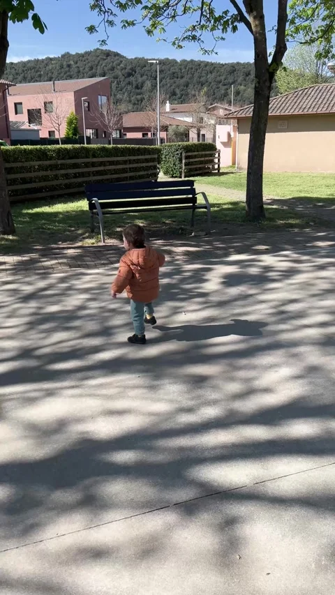 Toddler boy learning to walk in a sunny park with shadows Vídeos de archivo 336625559