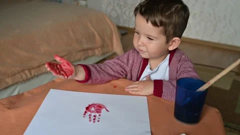 Toddler boy making colored handprints on white background. Little child rejoices Stock Footage 172590689