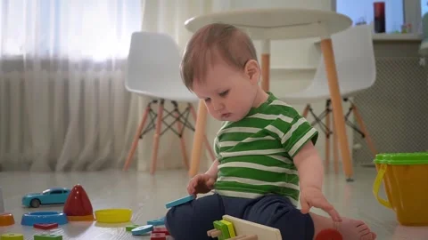 Toddler boy is playing with educational geometric sorter at home. Early Stock Footage 244262924