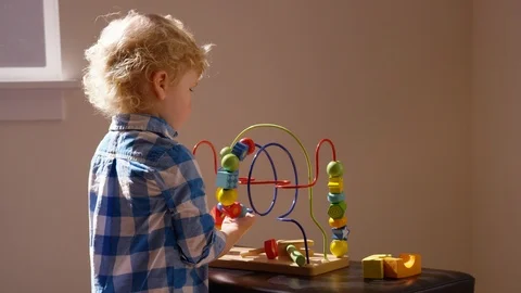 Toddler boy plays with bead roller coaster maze cognitive development toy Stock-Footage 94687136