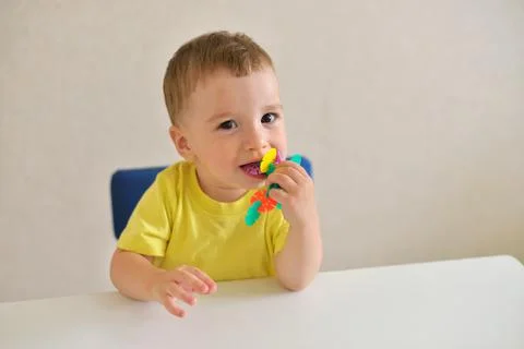 Toddler boy plays constructor while sitting at a white table. educational gam Foto stock