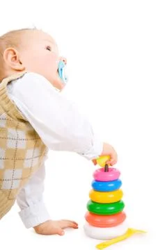 The toddler boy plays developing game. color pyramidion. Stock Photos