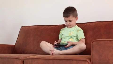 Toddler boy pressing and scrolling with finger on phone touch screen. Cute Stock Footage 246692029