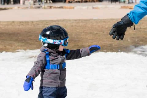Toddler Boy Ready to Ski Dressed for Safety with his Father. Stock Photos