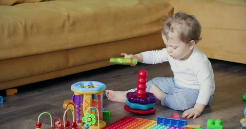 Toddler boy with serious expression plays with constructor 動画素材 253626756