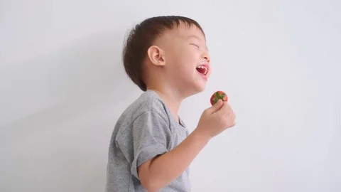Toddler boy using hands eating strawberry Stockbeeldmateriaal 103309304