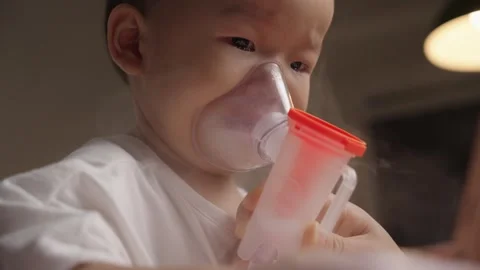 Toddler Boy Using Nebulizer Mask for Asthma Treatment at Home Video stock 339078196
