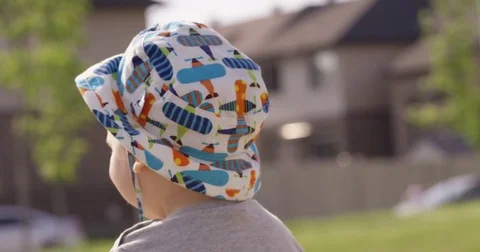 Toddler boy walking around in park from behind - slow motion Stock Footage