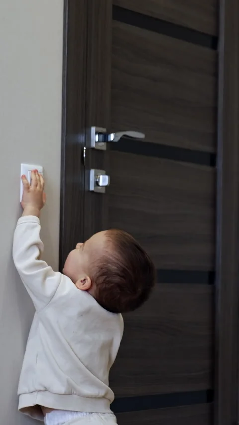 Toddler boy walks up to a light switch. Stock Footage 301879155