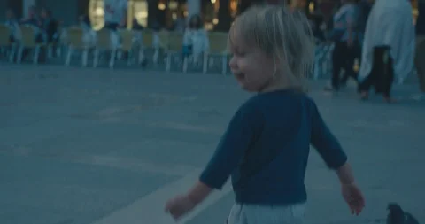 Toddler chasing pigeons in Venice Stock Footage 97492282