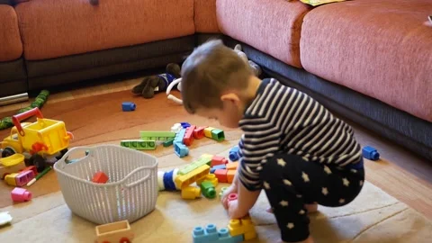 Toddler child doing mess at home. Naughty boy throwing toys in his room. Stock Footage 153397057