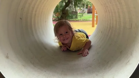 Toddler crawling through playground Stock Footage 336321225