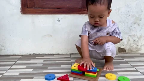 Toddler Developing Fine Motor Skills with Occupational Shape Sorter Stock Footage 328296533