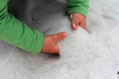 Toddler Digging Hands in Sand Foto stock