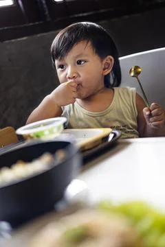 Toddler Is Eating Breakfast By Himself Stock Photos