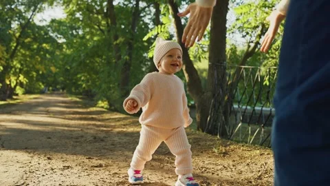 Toddler enjoys sunny stroll through lush green park in the afternoon light Stock Footage 307121453