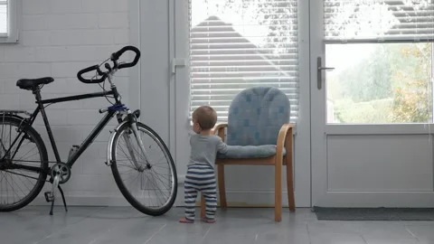 Toddler explores the street through the window Stock Footage 333798176