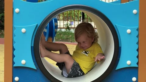 Toddler exploring blue playground Stock Footage 336278187
