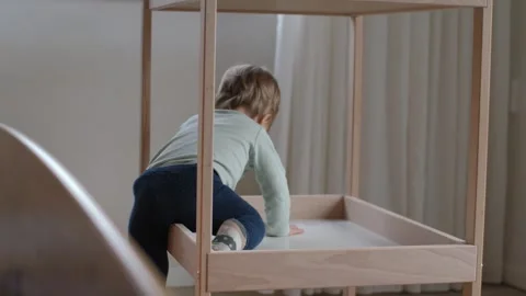Toddler exploring wooden changing table Stock Footage 322681554