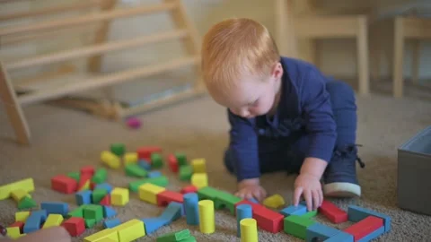 Toddler Focused on Building with Blocks curious toddler deeply engaged in Stockbeeldmateriaal 296088979