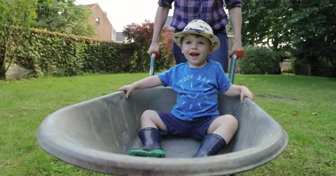 Toddler getting a ride in a wheel barrow Stock Footage 65167428
