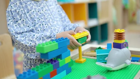 Toddler Girl Playing with Construction Interlocking Plastic Bricks Lego Stock Footage 254549332
